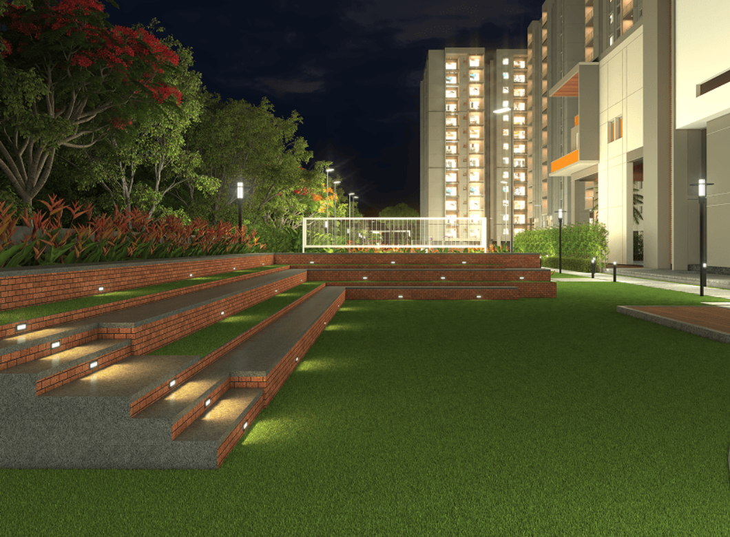 Beautifully lit amphitheater seating area with tiered landscaping and residential towers at night